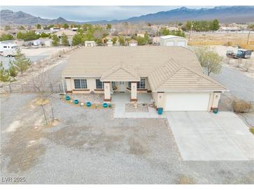 Expansive single-story home with a neutral color palette, covered porch, and desert landscaping at 620 W Leffner Dr, Pahrump, NV 89060