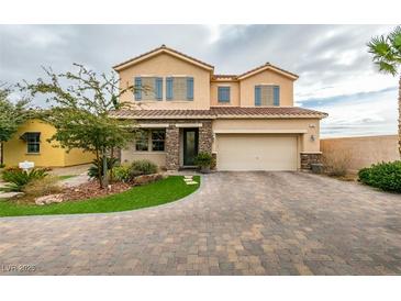 Charming two-story home featuring a well-manicured lawn, two-car garage and beautiful stone accents at 748 Fast Green Way, Las Vegas, NV 89148