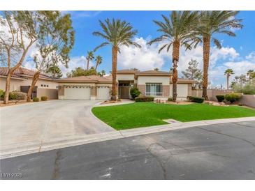 Charming single-story home featuring a three car garage, manicured landscaping, and tall palm trees at 7816 Sandy Eagle Ct, Las Vegas, NV 89129