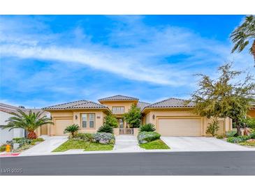 Beautiful single-story stucco home with a three-car garage, tile roof and well-manicured front yard at 11593 Glowing Sunset Ln, Las Vegas, NV 89135