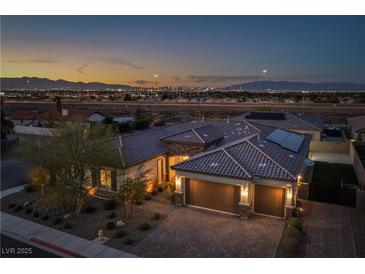 Stunning home with a three-car garage and beautiful desert landscaping at dusk at 3012 Joy Meadow Ave, Henderson, NV 89074