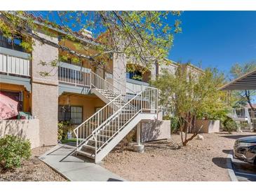 Condo exterior with stairs leading to the second floor, natural desert landscaping, and covered parking at 5166 S Jones Blvd # 202, Las Vegas, NV 89118