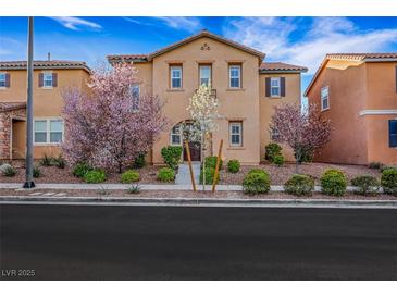 Charming two-story home with a well-manicured lawn and beautiful flowering trees at 3189 Sisley Garden Ave, Henderson, NV 89044