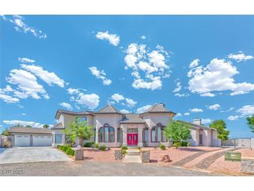 Elegant two-story home featuring symmetrical design, a red door, and a manicured landscape at 6965 S Valley View Blvd, Las Vegas, NV 89118