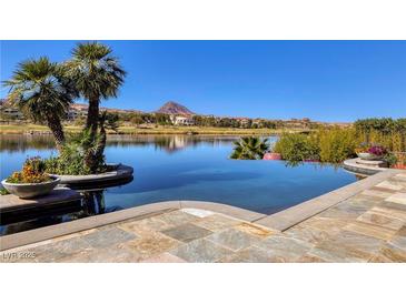 Gorgeous infinity pool overlooking a serene lake and mountain landscape with clear blue skies and palm trees at , Henderson, NV 89011
