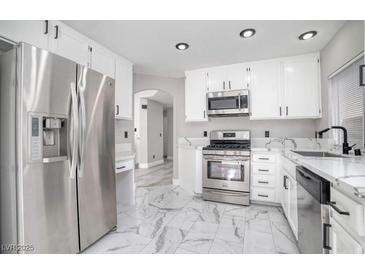 Modern kitchen with stainless steel appliances and white cabinets at 1216 Padre Serra Ln, Las Vegas, NV 89134