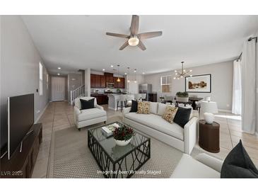 Bright living room with ceiling fan, white sofa, and direct access to the kitchen and dining area at 2785 Donatello Manor Pl, Henderson, NV 89044