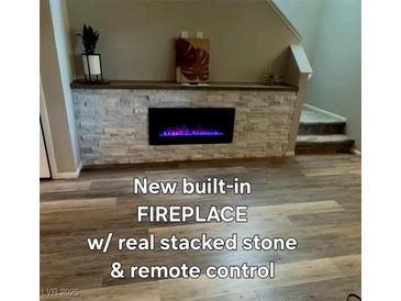 Modern fireplace with stacked stone and a dark mantel creates a focal point at 2844 Alenga St, Henderson, NV 89044