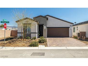 Charming single-story home featuring a landscaped front yard and a two-car garage with a brick-paved driveway at 4743 S Sungold St, Pahrump, NV 89061