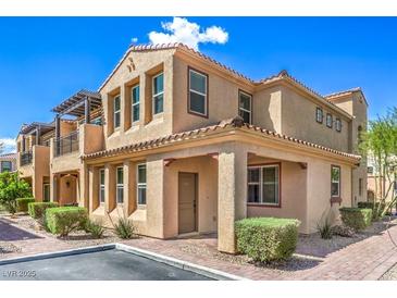 Inviting stucco condo showcasing a red tile roof, small front yard, and a private outdoor patio on the second floor at 1056 Via Panfilo Ave, Henderson, NV 89011