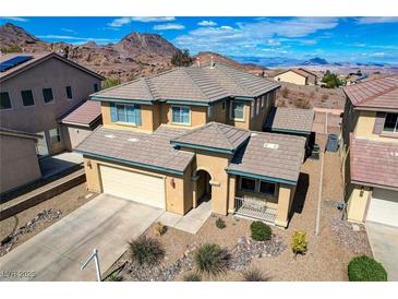 Stunning two-story home boasts a tile roof, desert landscaping, and a two-car garage, set against a mountain backdrop at 112 Austin Rose Ave, Henderson, NV 89002