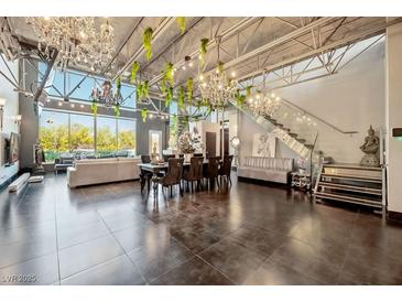 Open-concept living and dining area featuring soaring ceilings, chandeliers and abundant natural light at 5014 Thunder River Cir, Las Vegas, NV 89148