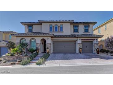 Charming two-story home featuring a tile roof, three-car garage, and manicured front landscaping at 12121 Cabo Rojo Ave, Las Vegas, NV 89138