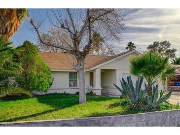 Inviting front yard featuring lush lawn, mature trees, and vibrant greenery enhance curb appeal at 2367 E Hacienda Ave, Las Vegas, NV 89119