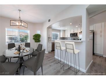 Bright dining area and kitchen featuring an open layout, stainless steel appliances, and modern countertops at 6160 Rumrill St # 201, Las Vegas, NV 89113