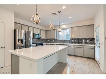 Modern kitchen features stainless steel appliances, a large island, and decorative backsplash at 8031 Tank Loop St, Las Vegas, NV 89166