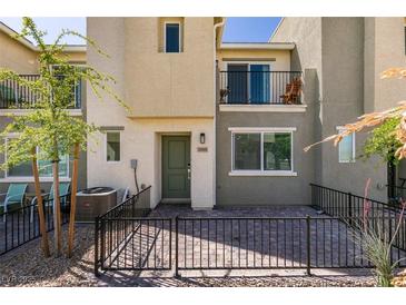 Charming townhome featuring a cozy front patio with iron fencing and desert landscaping at 2598 Mocha Pearl Ct, North Las Vegas, NV 89086