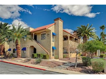 Inviting two-story condo with desert landscaping, palm trees, and red tile roof at 4706 Obannon Dr # C, Las Vegas, NV 89102