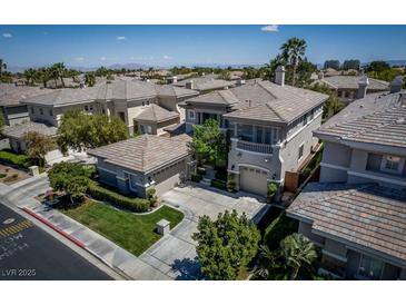An aerial view of a two story stucco home featuring tile roof, balcony, and landscaped surroundings at 504 Pinnacle Heights Ln, Las Vegas, NV 89144