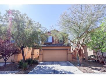 Charming two-story home featuring a well-maintained front yard and a two-car garage, offering curb appeal and convenience at 7403 Benlomond Ave, Las Vegas, NV 89179