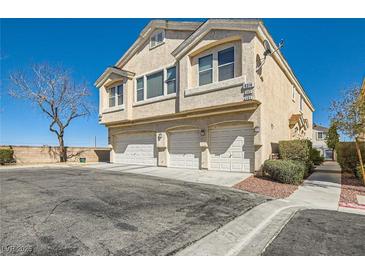 Inviting townhouse featuring three garage spaces and a light stucco exterior, perfect for modern living at 9314 Indian Corn Ct # 102, Las Vegas, NV 89178