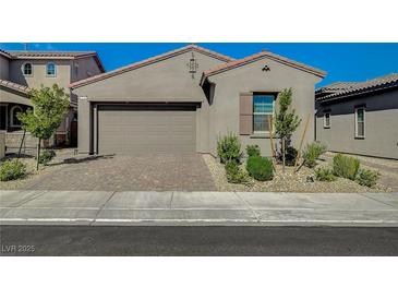 Charming single-story home features a brick driveway, a neutral color palette, and low-maintenance landscaping at 9940 Heather Moore Ave, Las Vegas, NV 89166