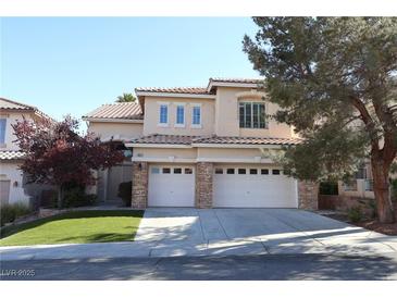Two-story home with a three-car garage, desert landscaping, and a red tile roof at 10657 Blue Nile Ct, Las Vegas, NV 89144