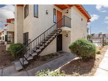 Charming condo featuring an exterior staircase leading to the unit's entrance and desert landscaping at 1701 E Katie Ave # 57, Las Vegas, NV 89119
