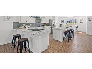 Bright kitchen boasts marble countertops, stainless steel appliances, and a large island with bar seating at 3492 Edison Ave, Las Vegas, NV 89121