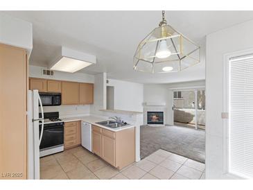 Bright kitchen featuring ample counter space, modern appliances, and a stylish hanging light fixture at 5265 Caspian Springs Dr # 201, Las Vegas, NV 89120