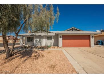 Home with a large, two-car garage door and low-maintenance desert landscaping in the front yard at 6284 Pinewood Ave, Las Vegas, NV 89103