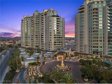 Luxury high rise at dusk featuring manicured grounds, circular driveway, and fountain at 9101 Alta Dr # 205, Las Vegas, NV 89145