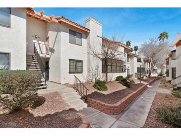 Charming condo featuring stucco walls, a red tile roof, and mature landscaping, offering a warm, inviting curb appeal at 1701 E Katie Ave # 36, Las Vegas, NV 89119