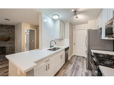 Modern kitchen features white cabinets, stainless steel appliances, and new hard surface countertops at 2200 S Fort Apache Rd # 2153, Las Vegas, NV 89117