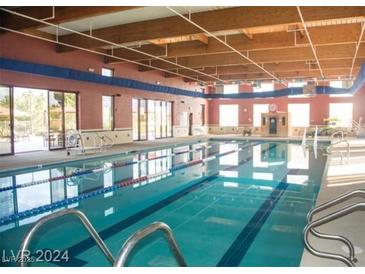 Large indoor pool with multiple lanes, accessible by stairs and exit to a patio at 3603 Herring Gull Ln, North Las Vegas, NV 89084