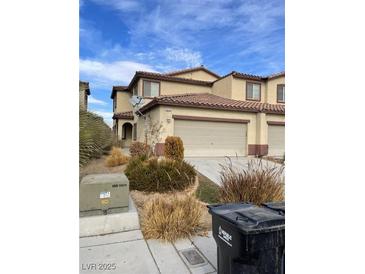 Tan two-story home with a well-manicured lawn, a two-car garage, and a brown roof at 4236 Thomas Patrick Ave, North Las Vegas, NV 89032