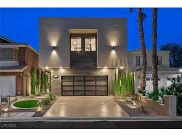 Contemporary home featuring a modern design with a glass garage door and minimalist landscaping at 2819 Queens Courtyard Dr, Las Vegas, NV 89109