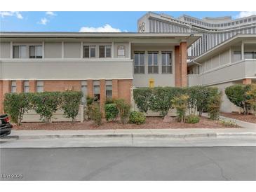 Multi-Gathering home featuring brick accents, complemented by lush landscaping and mature hedges at 2831 Geary Pl # 2912, Las Vegas, NV 89109