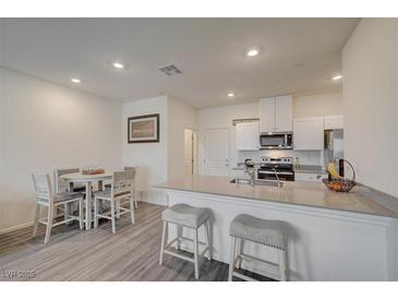Bright kitchen featuring a breakfast bar, stainless steel appliances, and an adjacent dining area at 542 Foothill Cove Ln, Henderson, NV 89002