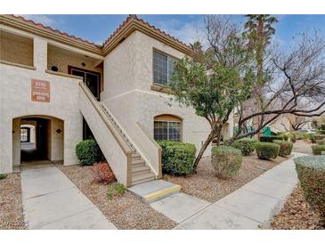 Charming condo featuring stucco exterior, desert landscaping, and convenient stair access to the upper level at 6705 Squaw Mountain Dr # 102, Las Vegas, NV 89130