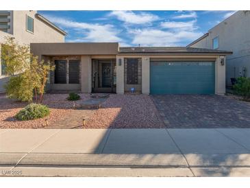 Inviting single-story home featuring a brick driveway, low maintenance yard, and modern architecture at 7177 W Camero Ave, Las Vegas, NV 89113