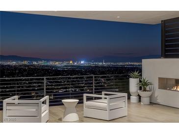 Relax on the balcony with an outdoor fireplace and seating, overlooking the spectacular city view at 9 Boulderback Dr, Henderson, NV 89012