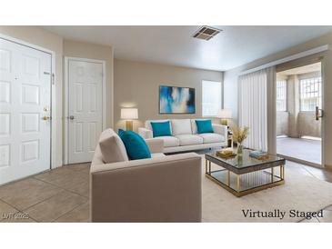 Bright living room features neutral walls, tile floors and a sliding glass door to the outdoor patio at 1560 Jamielinn Ln # 101, Las Vegas, NV 89110