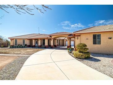 Spacious home featuring a long driveway and desert landscaping, enhancing curb appeal and offering ample parking at 671 W Hickory St, Pahrump, NV 89048
