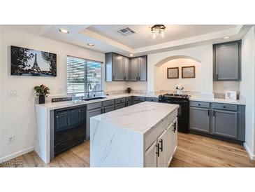 Modern kitchen featuring gray cabinets, marble countertops, and a stylish island at 830 Beartooth Falls Ct, Henderson, NV 89052