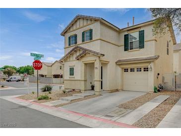 Two-story home showcasing desert landscaping, an attached garage, and complementary toned stucco, shutters and trim at 10265 Franford Ct, Las Vegas, NV 89183