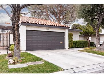 Exterior of home featuring a concrete driveway leading to a two car garage and tiled roof at 3440 Pino Cir, Las Vegas, NV 89121