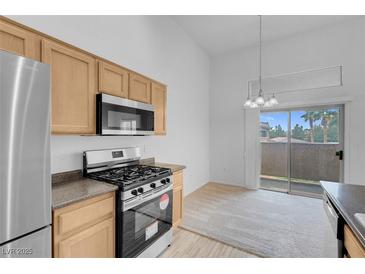Bright kitchen features stainless steel appliances, gas range, and sliding door to patio at 8805 Jeffreys St # 2082, Las Vegas, NV 89123
