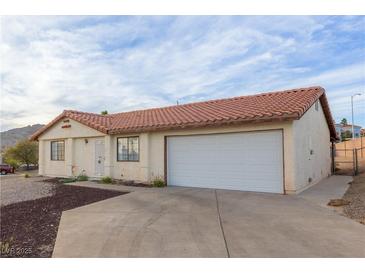 Cozy single-story home featuring a tile roof, neutral stucco and an attached two-car garage at 1892 Maricopa Dr, Laughlin, NV 89029