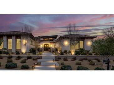 Beautiful exterior of home with desert landscaping and lighted walkway at 20 Pebble Hills Ct, Las Vegas, NV 89141